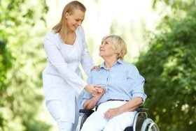 lady in wheelchair and carer walk outside
