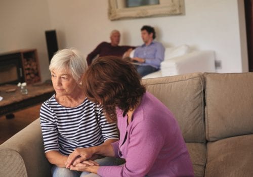 elderly lady seated on sofe talking about dementia with relative