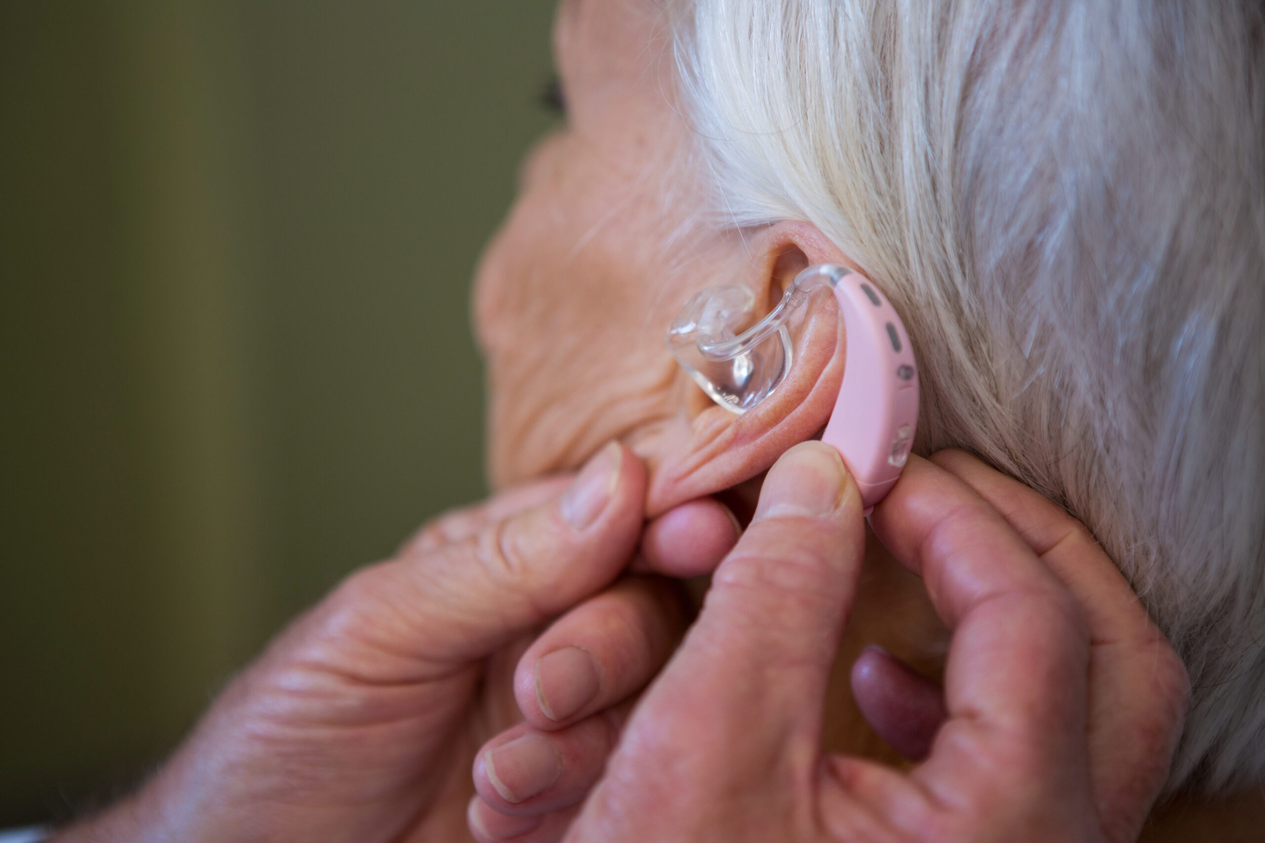 doctor inserting a hearing aid