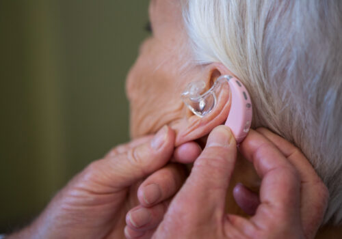 doctor inserting a hearing aid