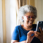 Senior woman using the mobile phone at home
