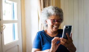 Senior woman using the mobile phone at home