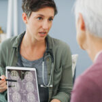 doctor showing brain scans to elderly lady
