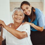 smiling lady and carer look at camera