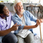 homecare worker and elderly lady sat smiling