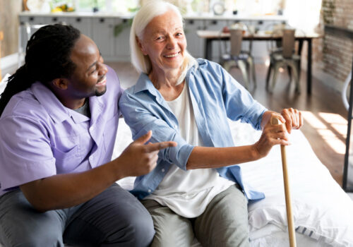 homecare worker and elderly lady sat smiling