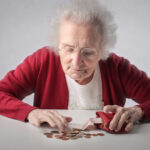 elderly lady counting money to pay for dementia care