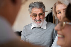 older man smiling with friends