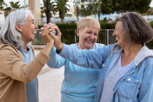 group of elderly ladies smiling holding bowl ball